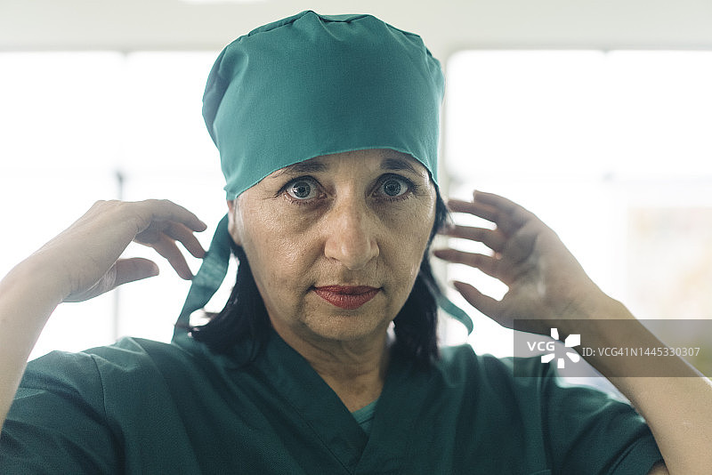 资深女外科医生穿手术服准备手术图片素材