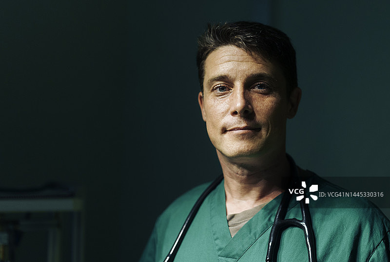 手术室里的专业外科医生肖像，深色背景图片素材