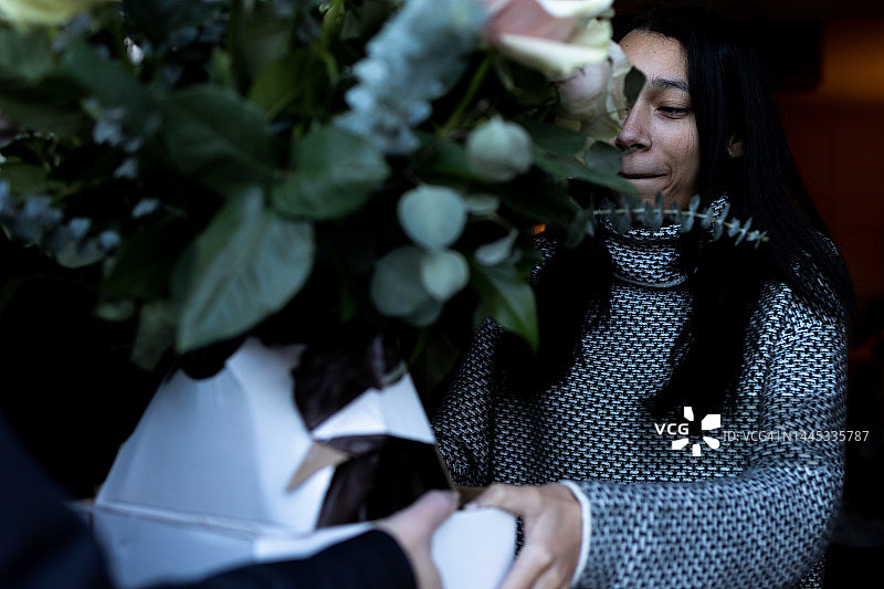 年轻混血女子与男子在门口手捧玫瑰花微笑图片素材