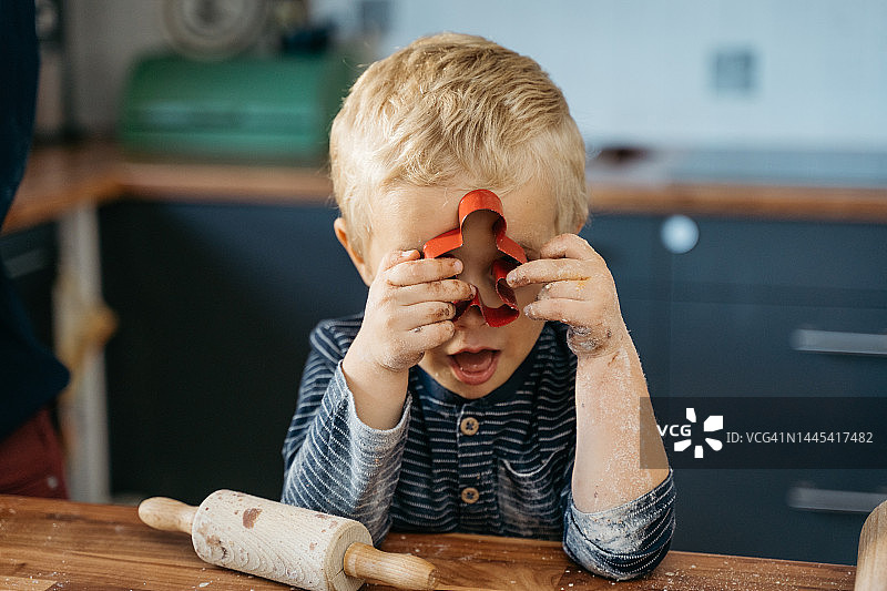 小男孩透过饼干模具向外看图片素材
