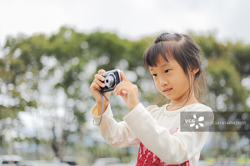 亚洲女孩用数码相机拍照图片素材