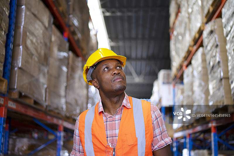 身穿蓝色工装的工人在仓库工作图片素材