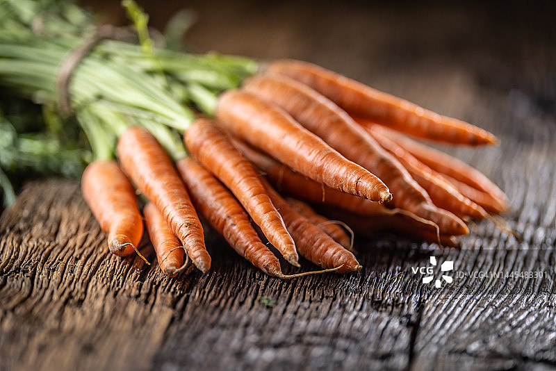 随意摆放在旧桌子上的新鲜胡萝卜图片素材