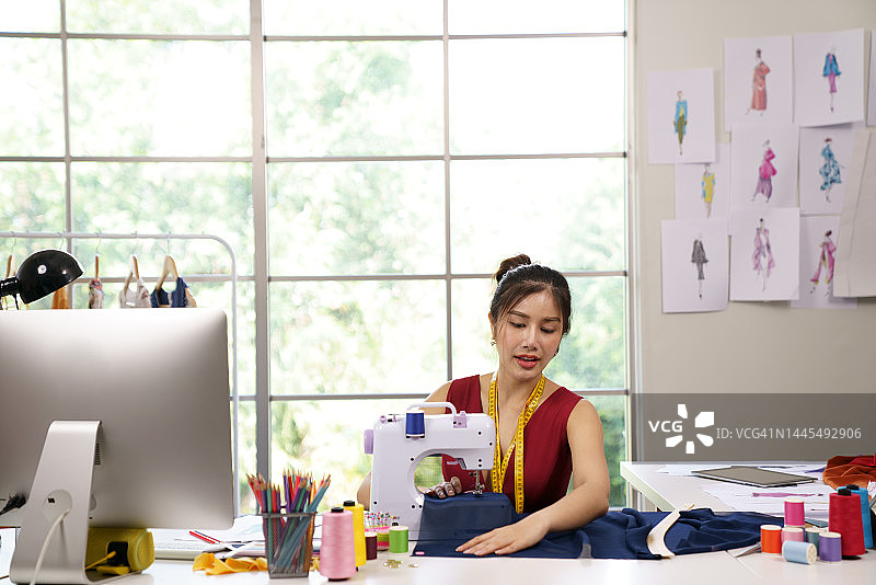 女裁缝使用缝纫机制作服装图案图片素材