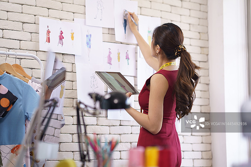 女裁缝在平板电脑上绘制服装图案设计草图图片素材