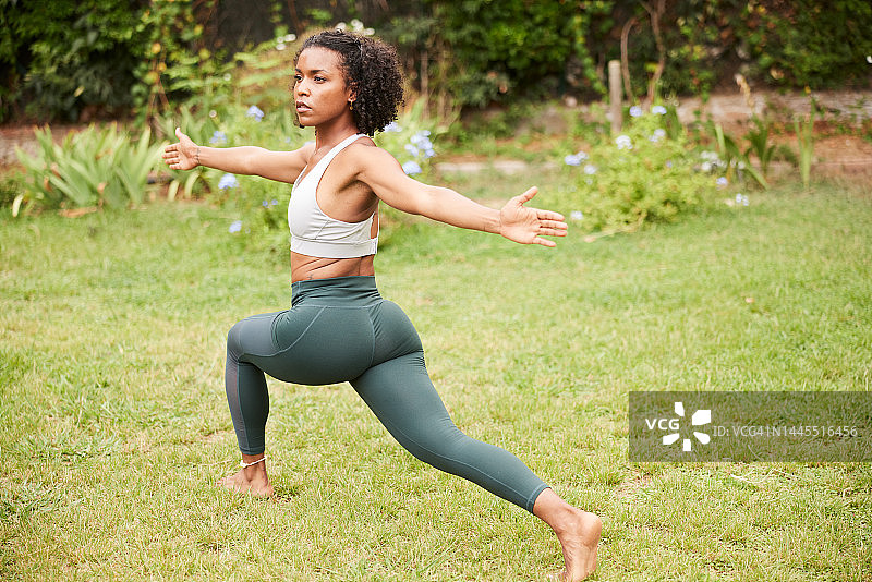 瑜伽教练在花园中练习瑜伽战士姿势图片素材