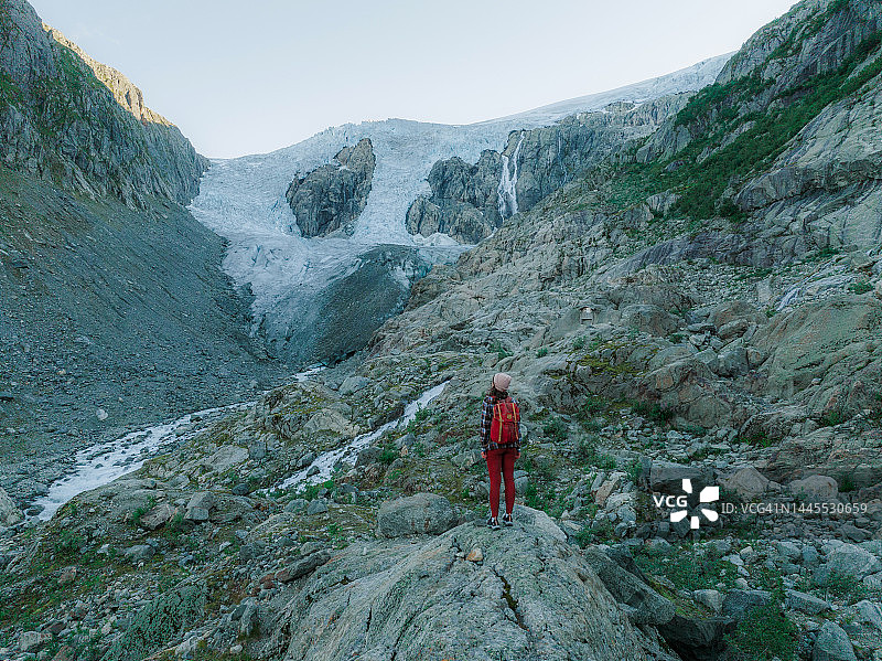 航拍女子在约斯特达尔冰川背景下徒步图片素材