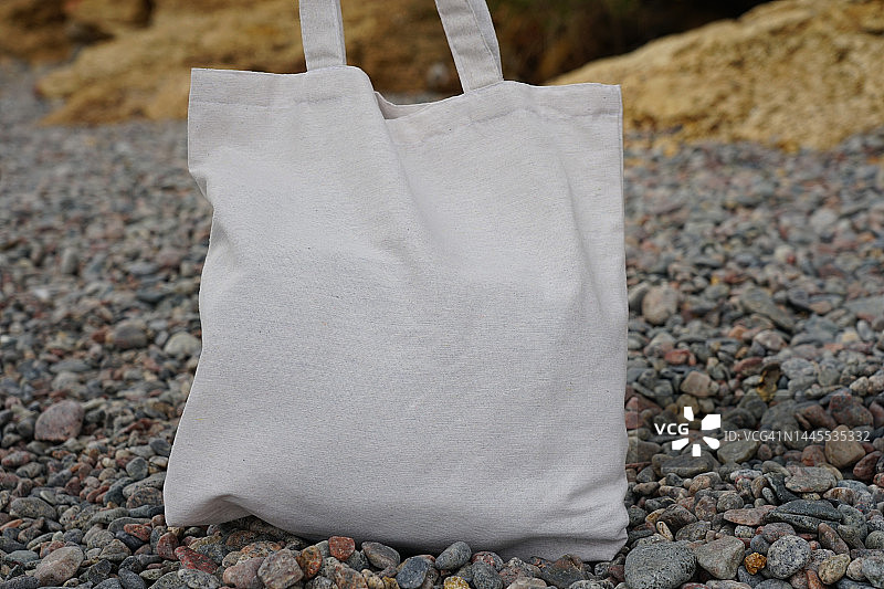 海边鹅卵石上的环保袋图片素材