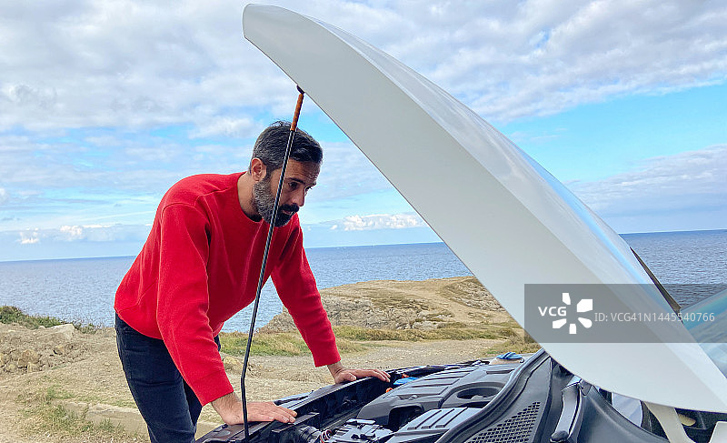 汽车抛锚，男子在路边检查汽车引擎图片素材