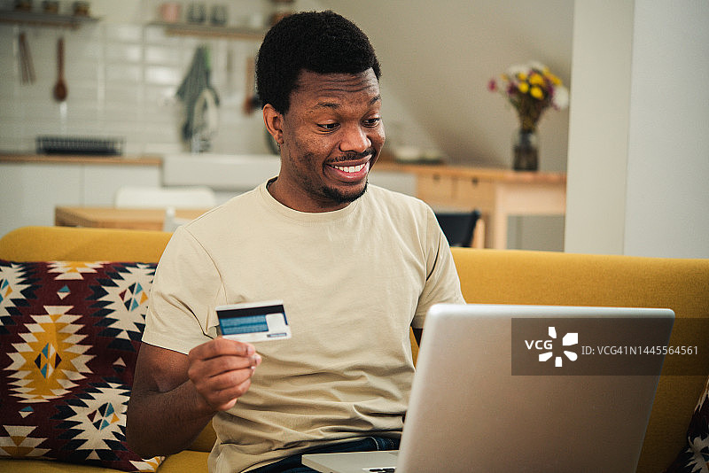 在家在线购物的年轻非洲男子肖像图片素材