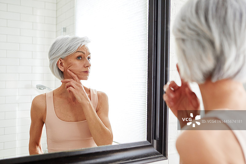年长的女人在浴室的镜子前图片素材