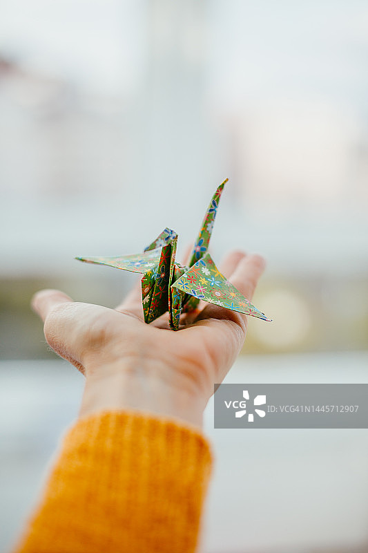 女人拿着折纸鹤图片素材