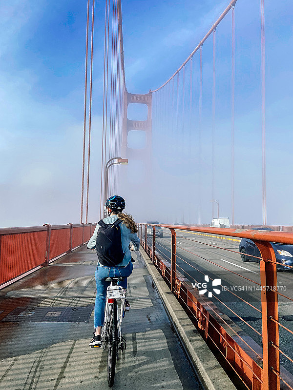 骑自行车经过金门大桥的女人图片素材