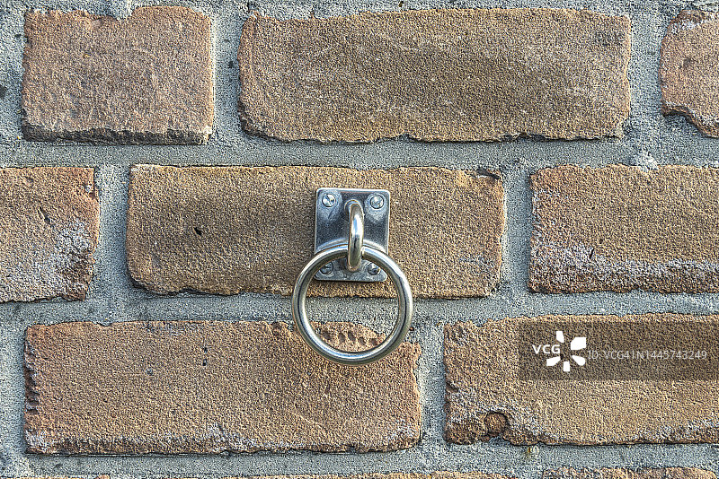 带有连接到方板的钢银环的石墙图片素材