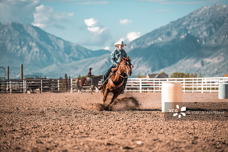 年轻女牛仔骑马绕桶赛图片素材