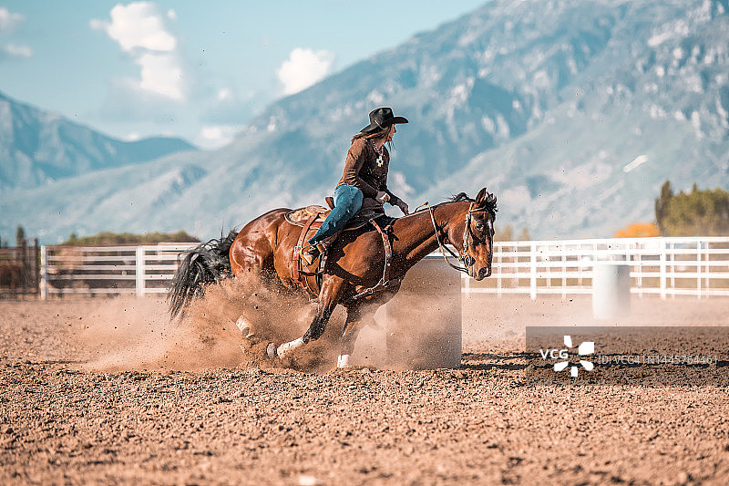 年轻女牛仔骑马绕桶赛图片素材