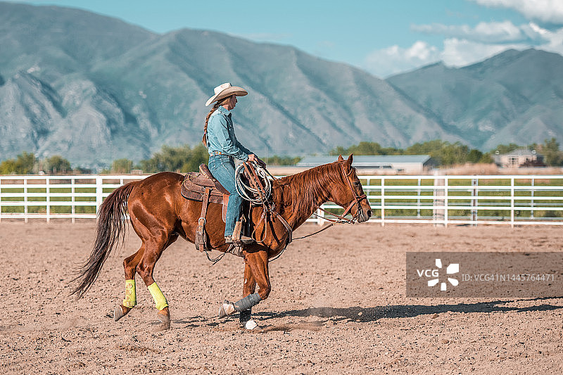 年轻女牛仔骑马绕桶赛图片素材