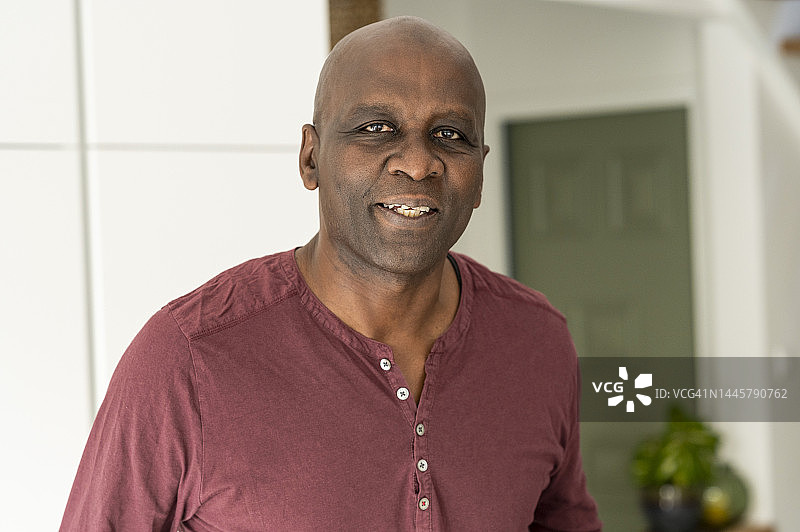 站在厨房里看着镜头的年长的非裔美国男人肖像图片素材