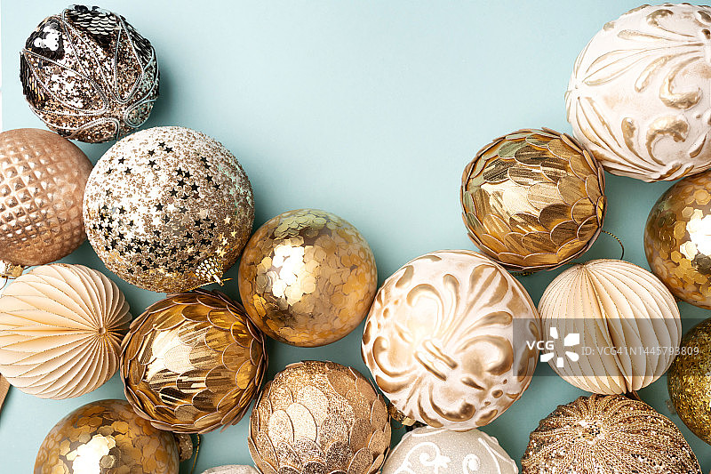 蓝色背景上许多金色复古风格圣诞装饰品的边框。新年快乐。自上而下的摄影，有复制空间供您设计图片素材