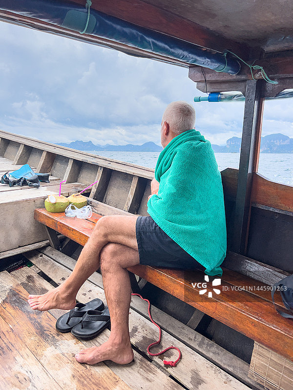 年长的男人在泰国乘坐长尾船图片素材