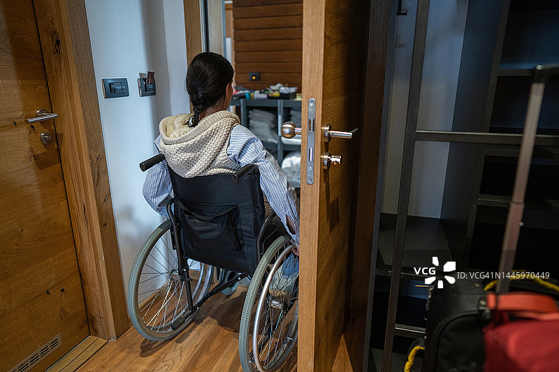 坐轮椅的伤残妇女离开酒店房间图片素材