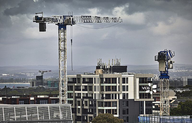 暴风云下的塔吊建筑与城市天际线图片素材