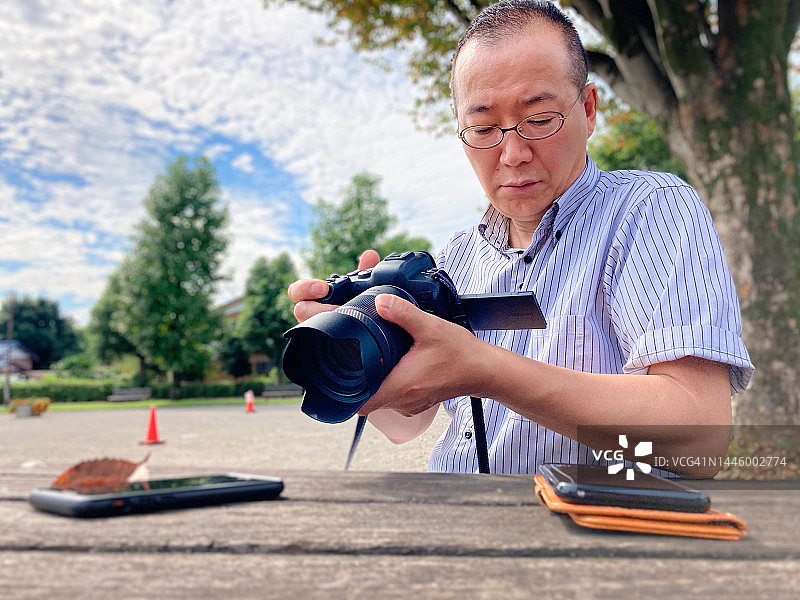 摄影师拍摄智能手机和树叶照片的幕后花絮图片素材