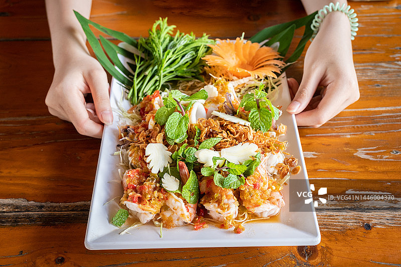 手捧泰式海鲜沙拉图片素材