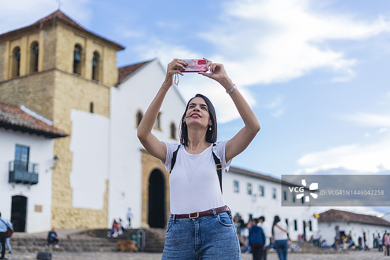 在莱瓦镇广场用手机和家人视频通话的拉丁裔女性图片素材