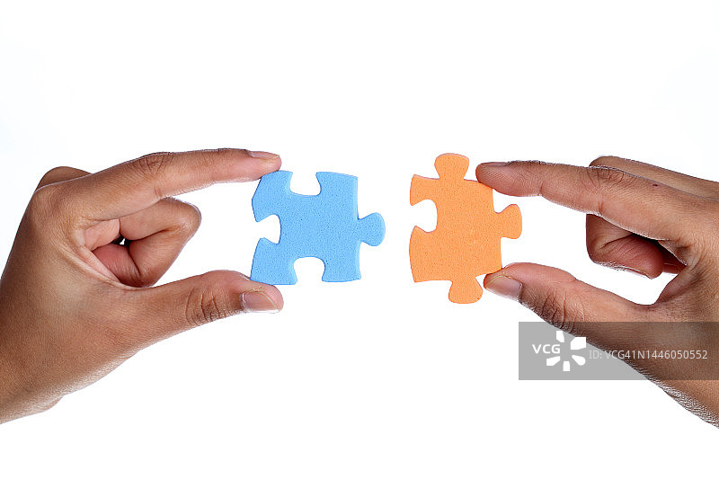 手持两块不同的拼图图片素材