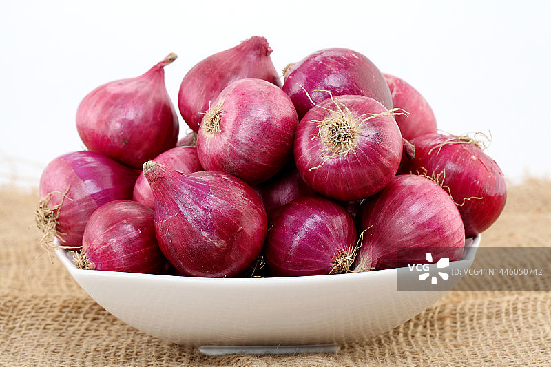 白色背景下白色碗里的红洋葱图片素材