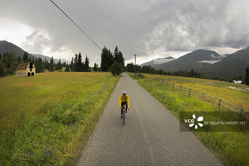 骑行在乡村道路上的通勤男人图片素材