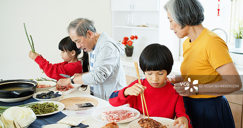 在厨房帮助祖父母的可爱儿童图片素材