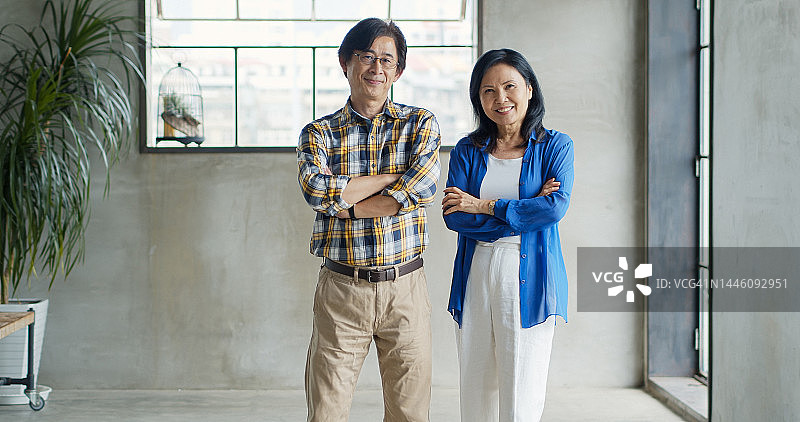 微笑并交叉双臂的亚洲商务夫妇图片素材
