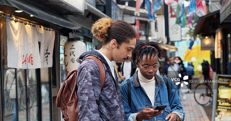 在日本看手机的年轻游客图片素材