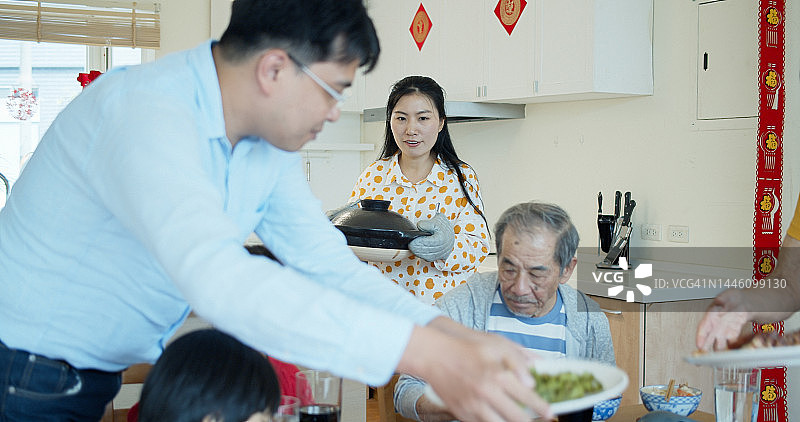中国新年，女人将火锅端上桌图片素材