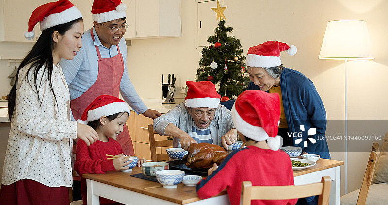 台湾爷爷在圣诞晚餐上切火鸡图片素材