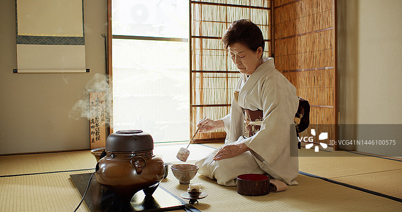 年长的茶道主持人量取热水图片素材