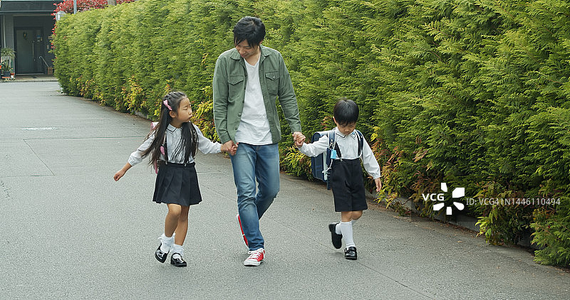 年轻的日本父亲送孩子上学图片素材