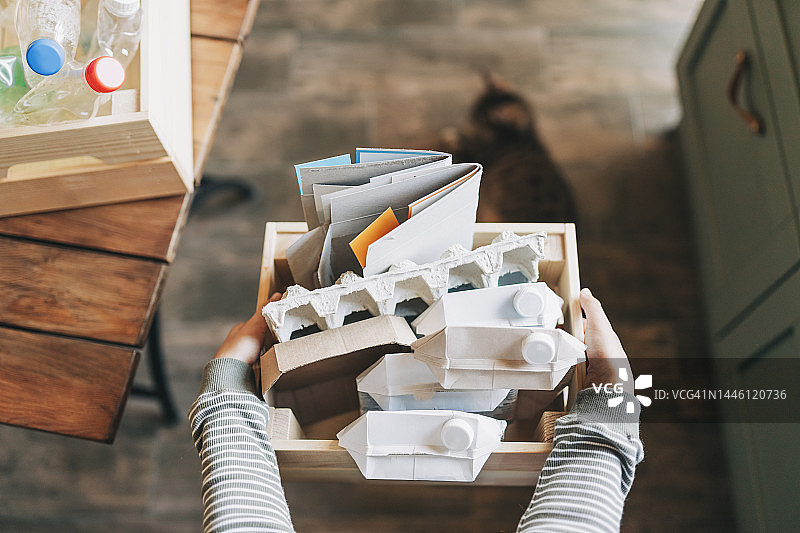 站在垃圾桶旁的微笑欧洲儿童，男孩正在扔掉分类的纸张和塑料，拯救自然环境。用于不同垃圾的金属垃圾桶，一种生态方法图片素材