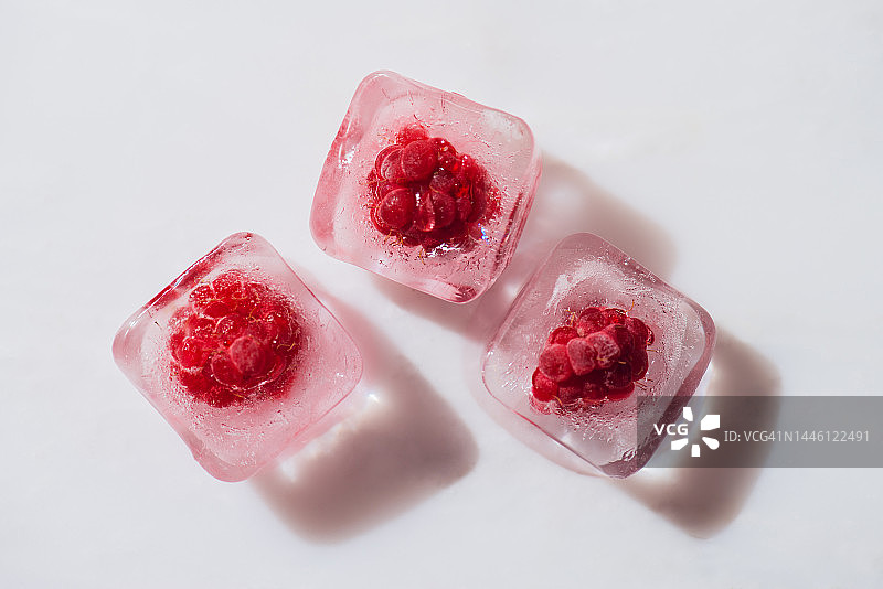 白色大理石表面上的冷冻覆盆子特写图片素材