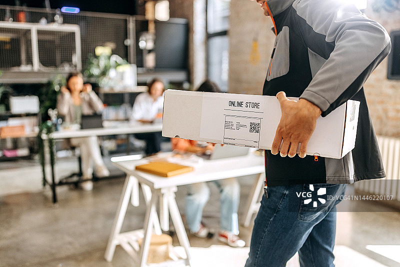 办公室里送货员拿着箱子的特写镜头图片素材
