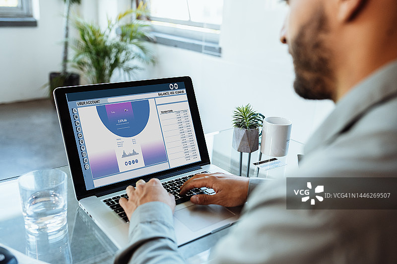 在办公室使用笔记本电脑进行电子银行的拉丁裔商人图片素材