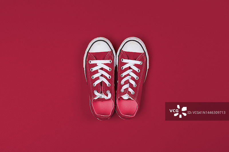 红色运动鞋俯视特写，彩色背景。2023年度流行色，维瓦洋红。图片素材