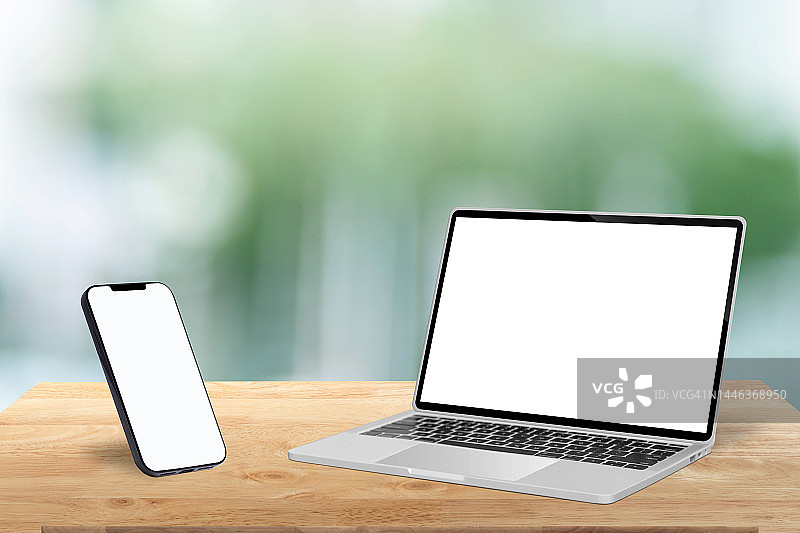 木桌上带空白屏幕的笔记本电脑和智能手机图片素材