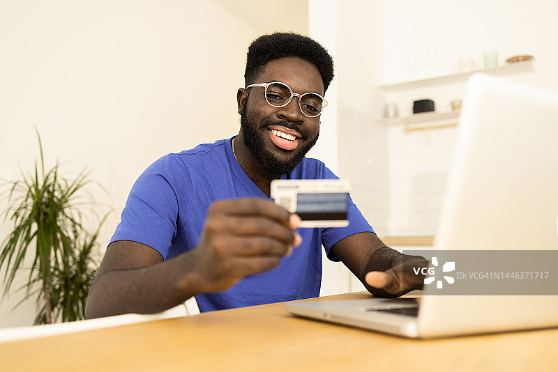 使用信用卡在线购物的男人肖像图片素材