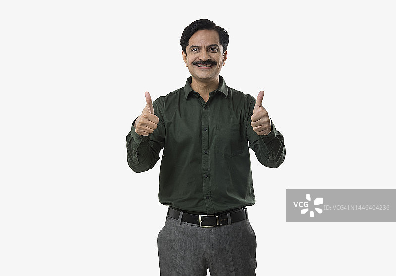 自信的男人在白色背景上竖起大拇指图片素材