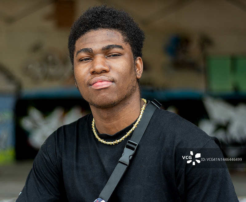 年轻黑人男孩的肖像，背景是涂鸦墙图片素材