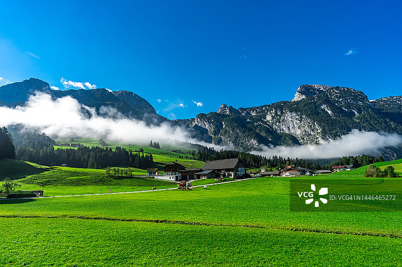 奥地利哈莱恩附近山丘上的乡村风光，背景是贝希特斯加登阿尔卑斯山图片素材