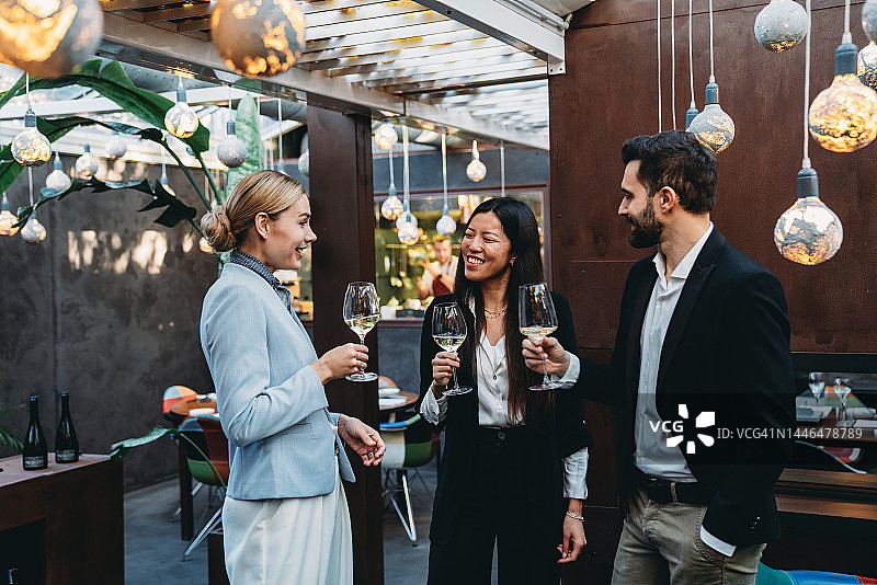 商务人士在餐厅喝酒交谈图片素材